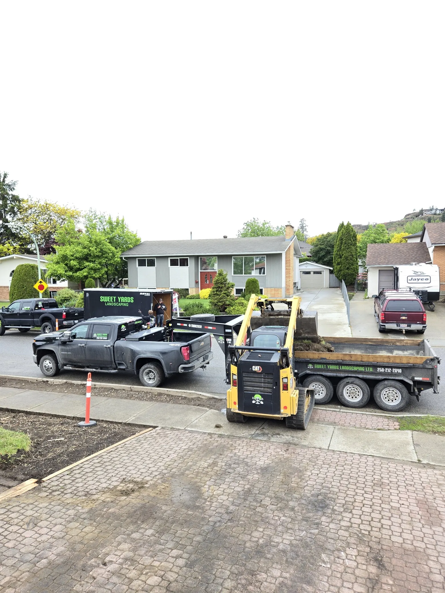Sweet Yards Landscaping truck trailer and loader loading dirt into the trailer